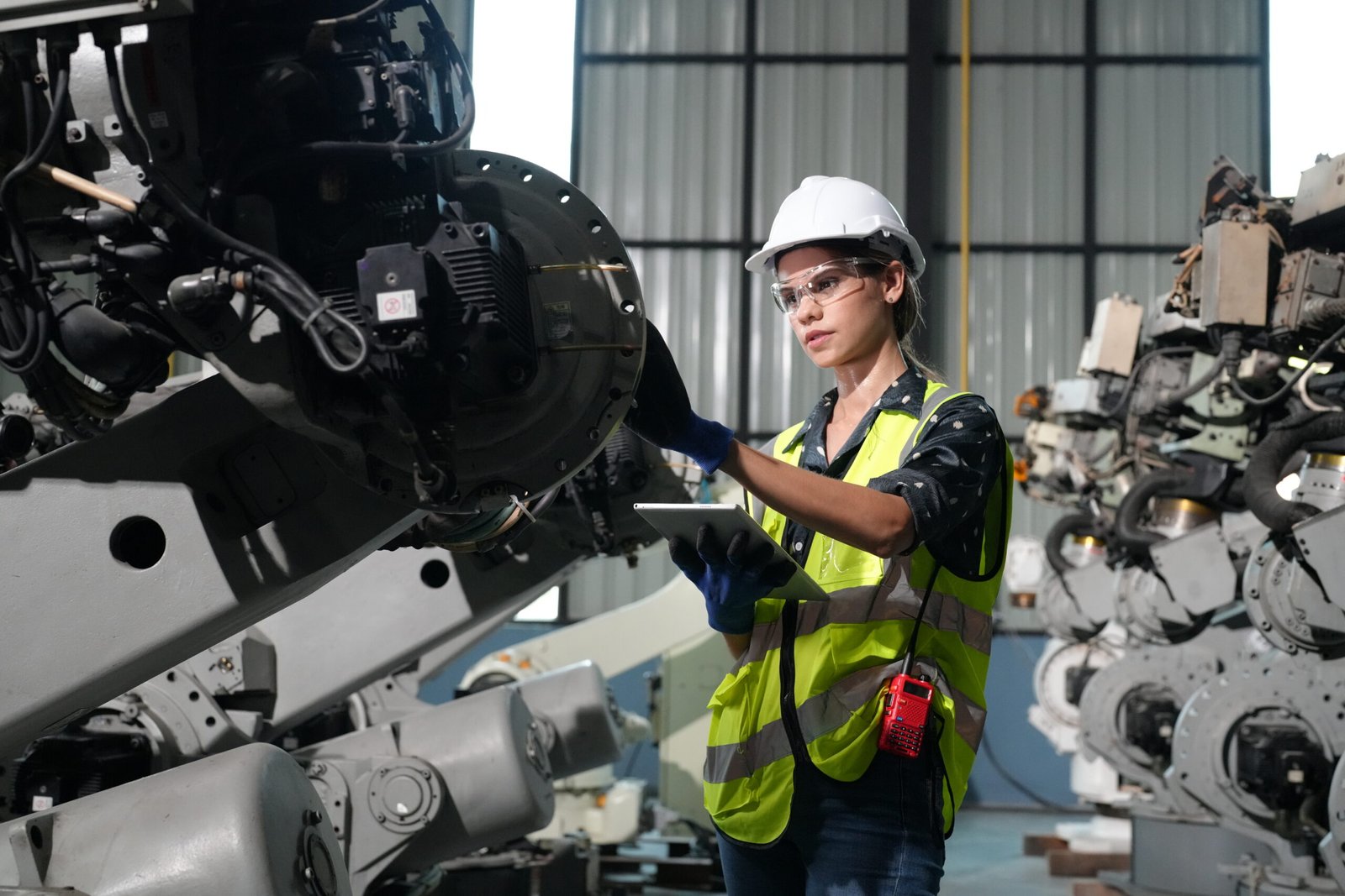 Robotic Arm engineer check on equipment in its with software of an Artificial Intelligence, Programming development technology work.
Female industrial engineer working at automated AI robotic production factory.